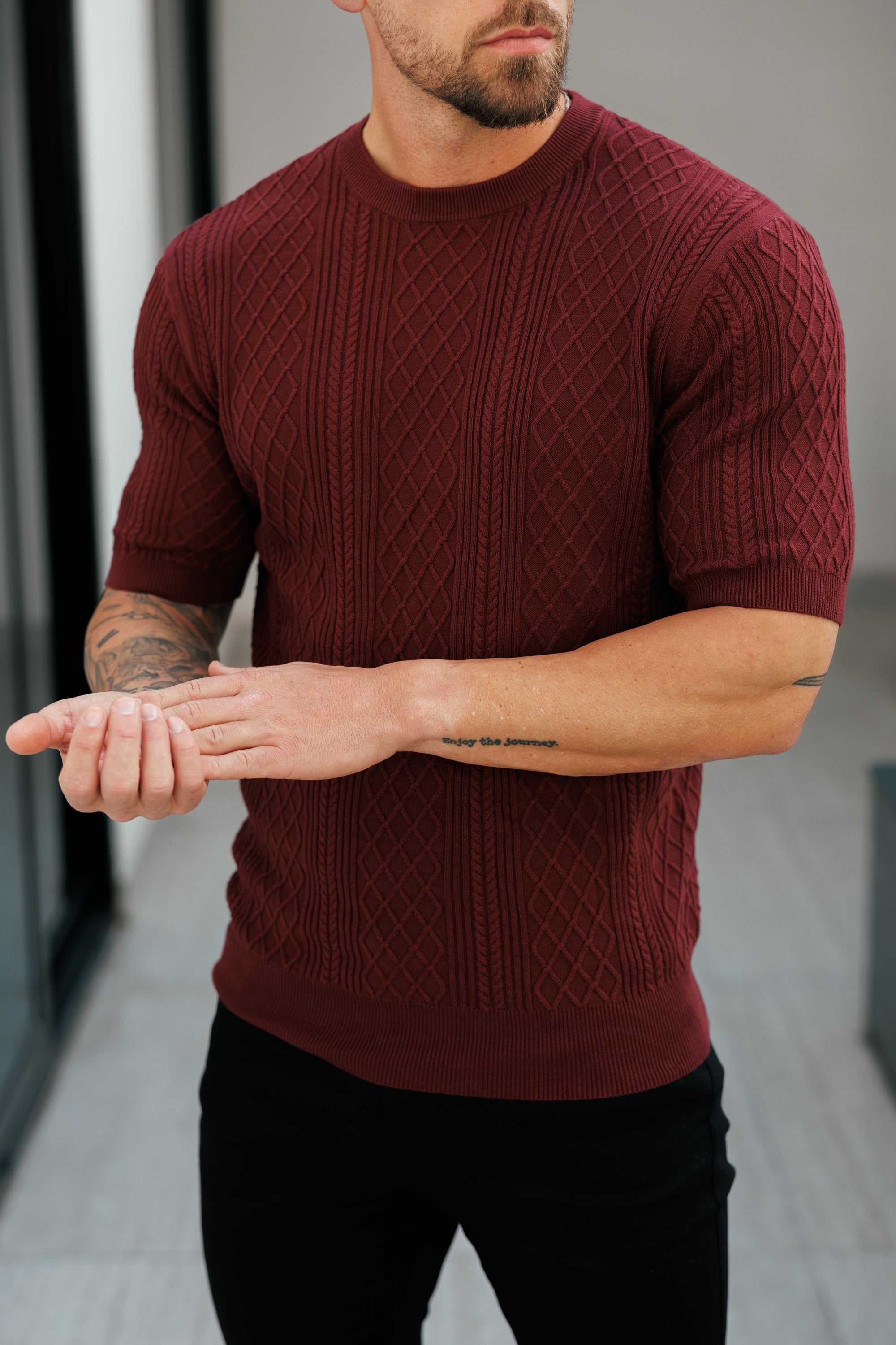 Man wearing a maroon sweater with a blurred background